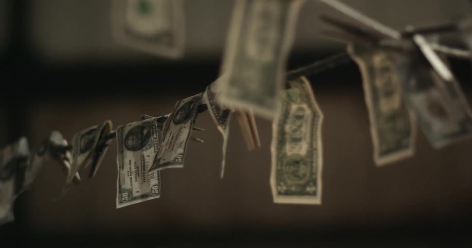 Us paper money is hanging over or clipped to a thick metal wire