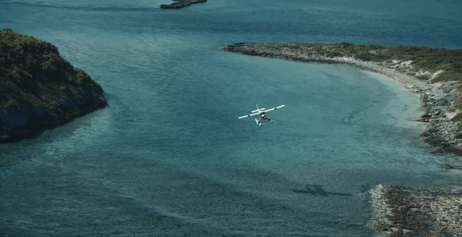 Aerial view of seaplane over ocean and small islands coming in for landing toward shore