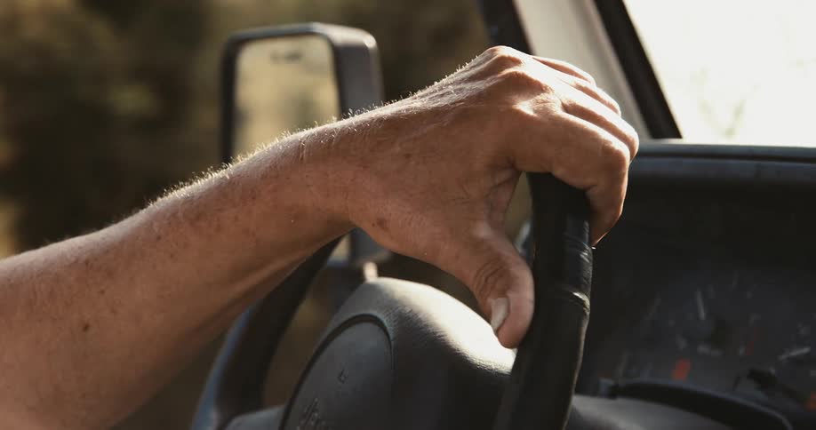 Close up view of a man driving a vehicle during the daytime