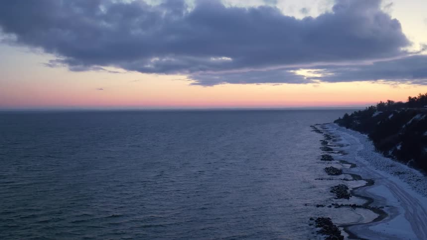 Ocean and beach coast is displayed during the sun setting