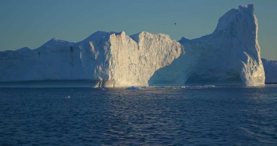 Aerial view of a large glacier floating in the arctic ocean at morning