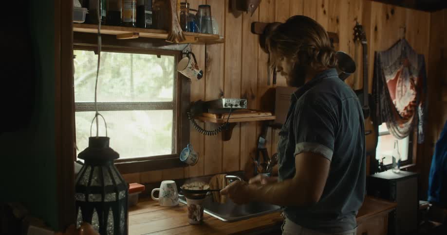 A man is making coffee in his kitchen