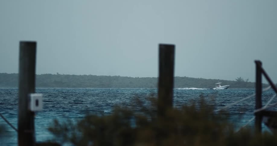 Motorboat moves across blue ocean ways leaving white wake