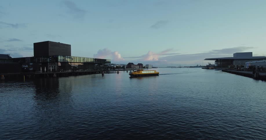 A waterway with shipping piers on both sides as a freight boat pulls into the dock