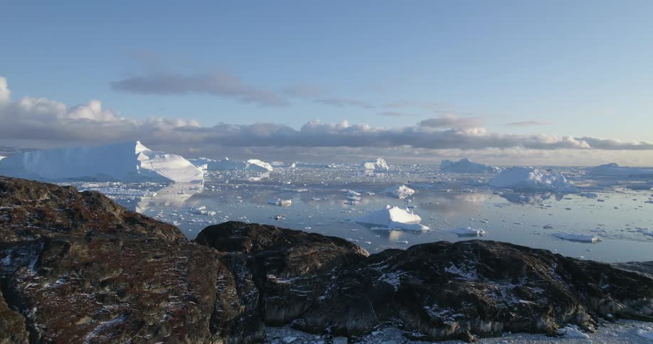Aerial view of snow melting in the ocean at dusk