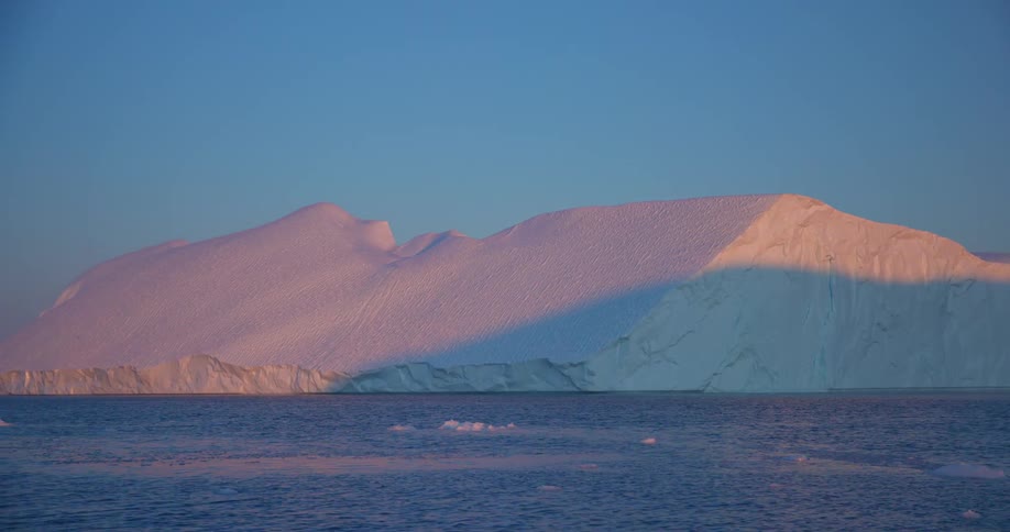 A large ice glacier as the ocean ripples toward the glacier