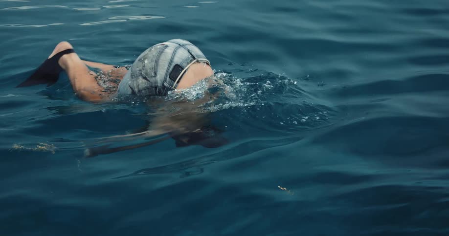 A man is diving into the ocean water during midday
