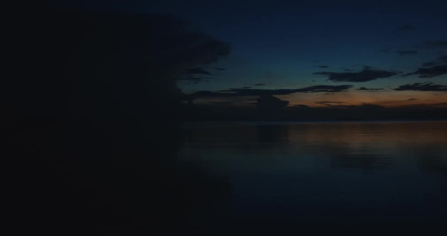 A thunderstorm in large clouds formed at night over the ocean