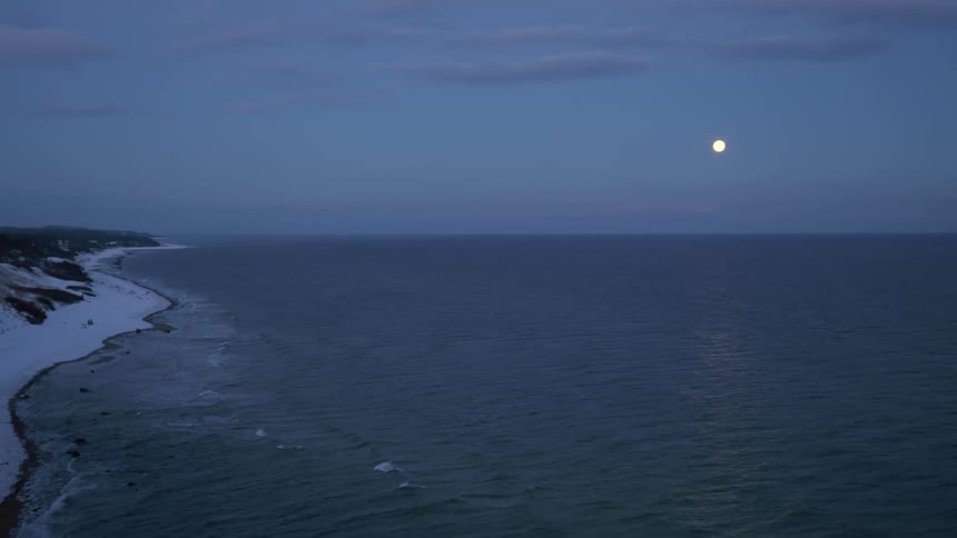 The beach coast during winter at night time is displayed