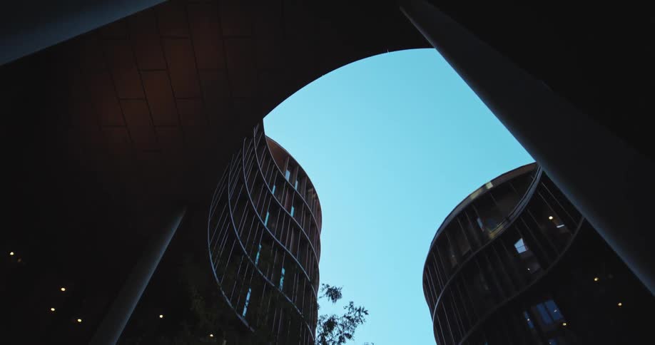 A large oddly shaped building with a courtyard with trees in the middle of the architecture