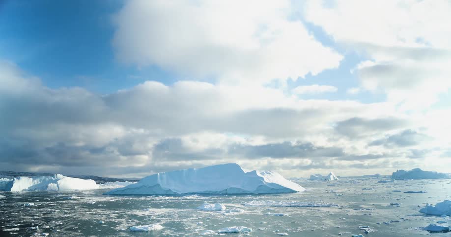 A time lapse of icebergs and glaciers on ocean waters as the clouds pass over