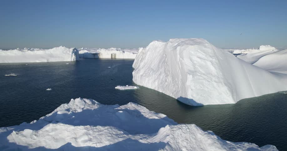 Aerial view of icebergs floating in the arctic ocean at daytime