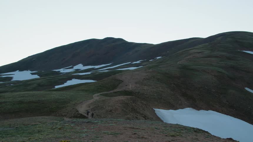 Two people are jogging through the wilderness in winter