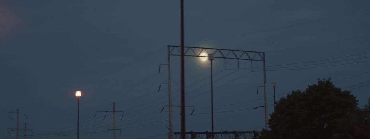 The moon moves across the sky above a city