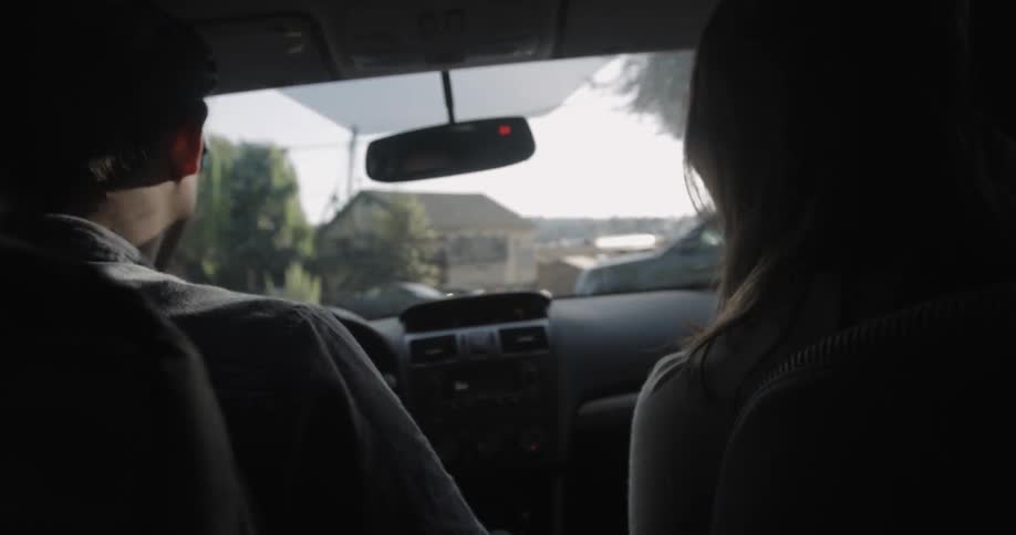 Two people are driving in a car