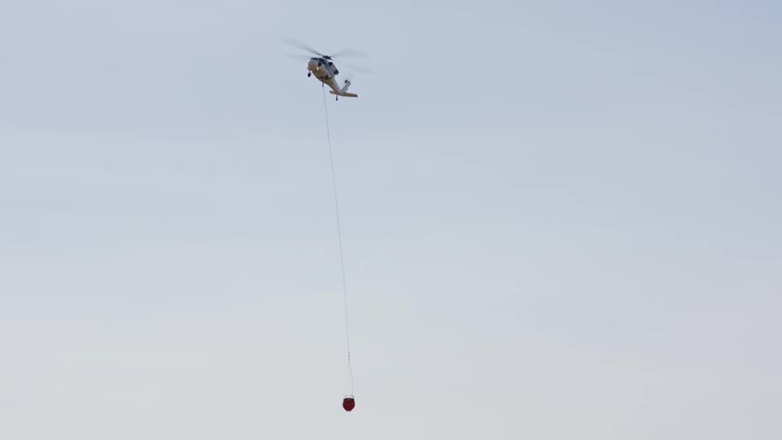 A helicopter flying lowers a container down
