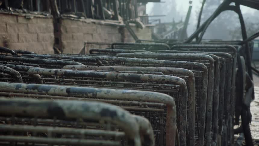 Close up of the burned remains of shopping carts next to a building after a fire