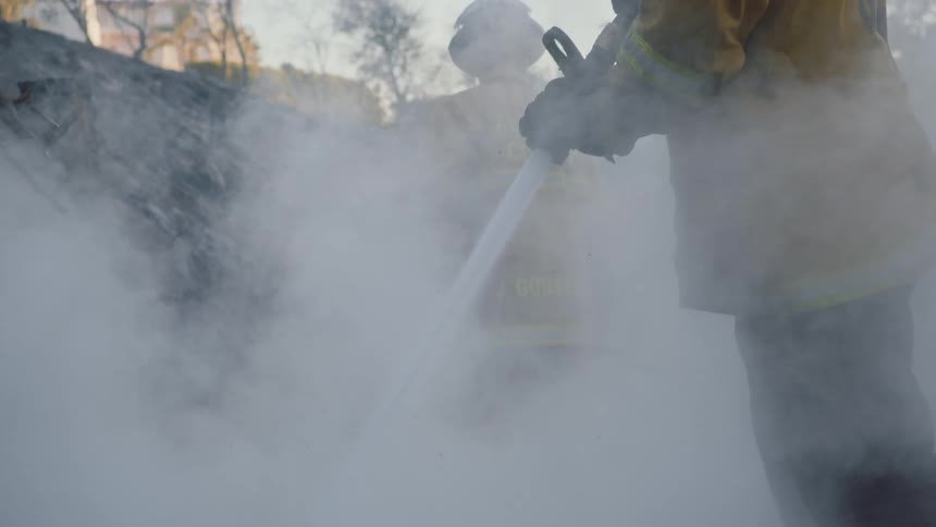 Firefighters shooting water at a forest fire