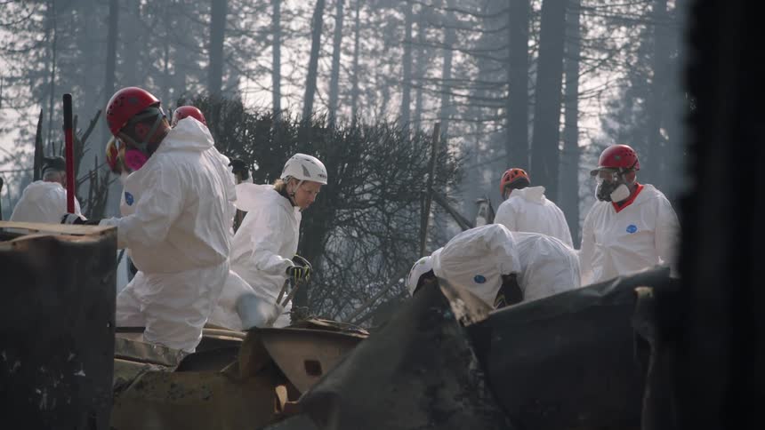People are clearing up the destruction from a fire