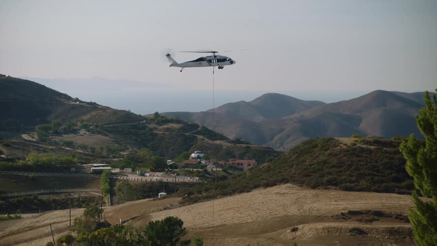 A helicopter is flying above the rural area