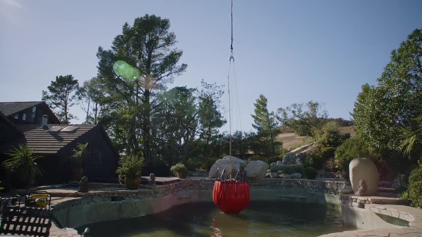 A helicopter bucket is filled up in a swimming pool and then transported in flight