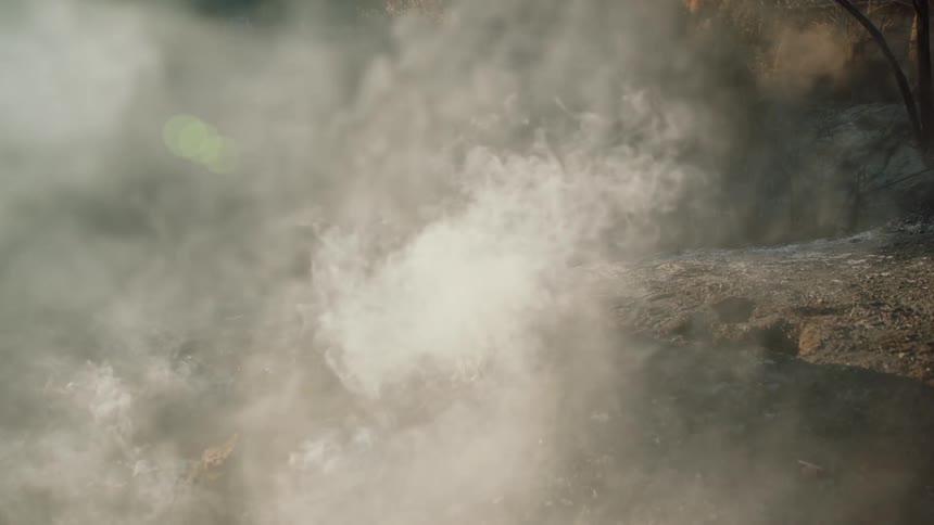 Smoke rolling off the ground around rock formations