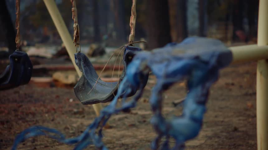 Plastic sections of a playground swing set are burned and melting