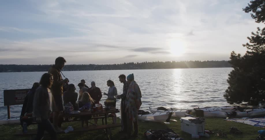 A group of people at a park near a lake