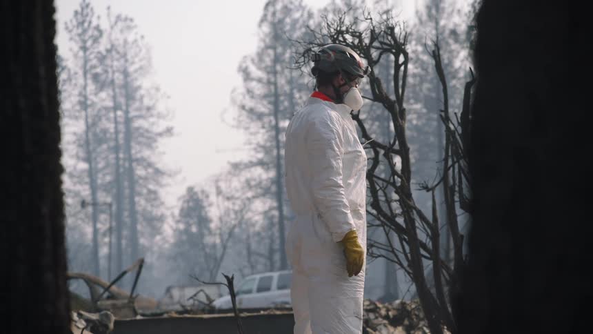 A worker stands in the burned down area