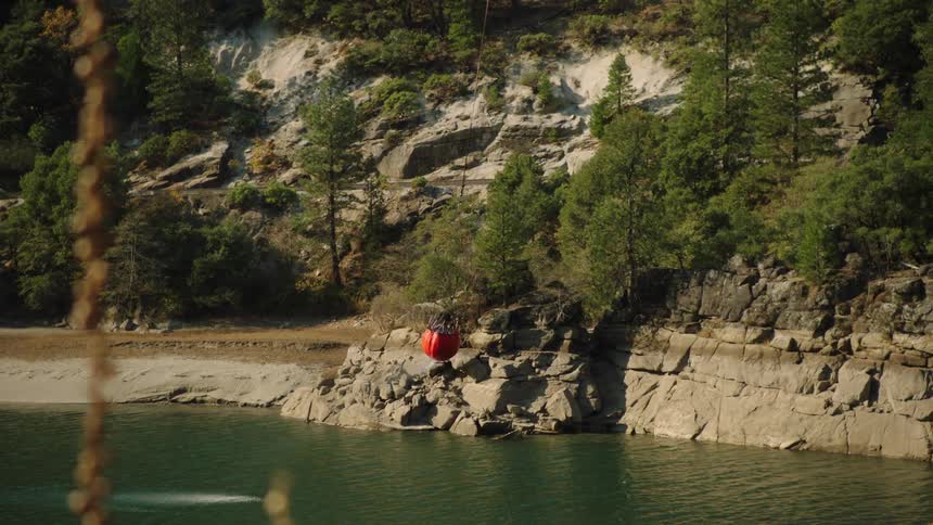 Helicopter bucket suspended on a cable carried by a helicopter to deliver water for aerial firefighting
