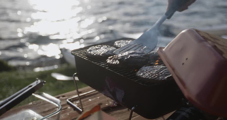 Hamburgers are being cooked on a grill