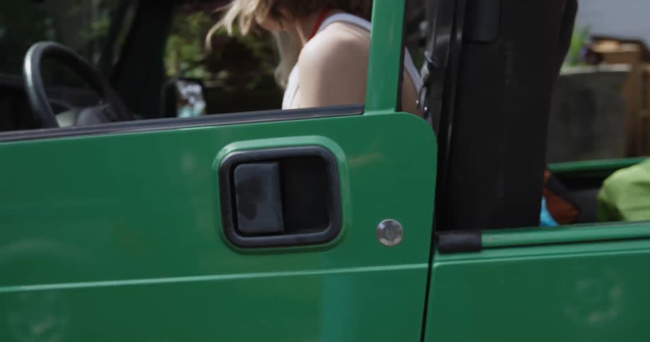A woman gets in a car and closes the door