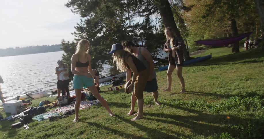 People are playing football near a lake