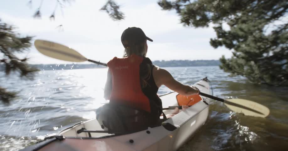 A woman is rowing her canoe out into the lake