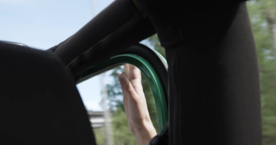 A person taps the vehicle from inside a moving car window
