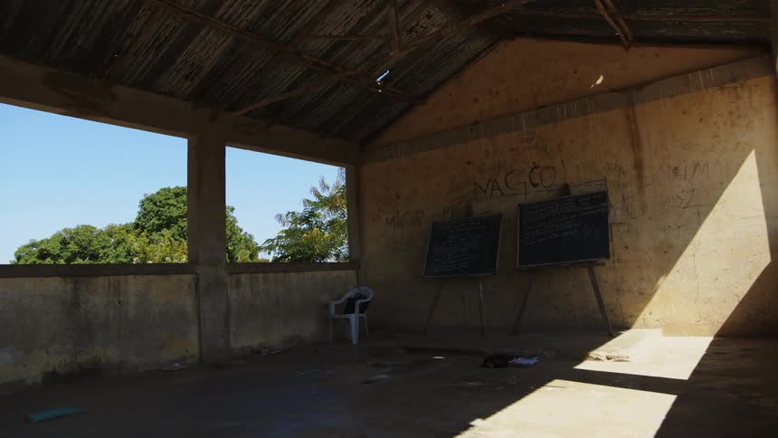 An interior of a building with no windows chalkboards and a chinar in the empty room