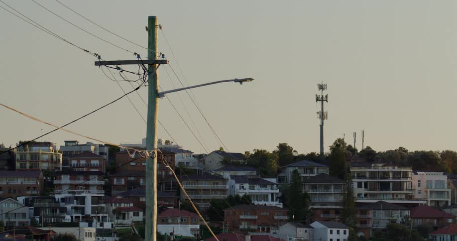 Transmission tower and utility towers stand over apartment buildings