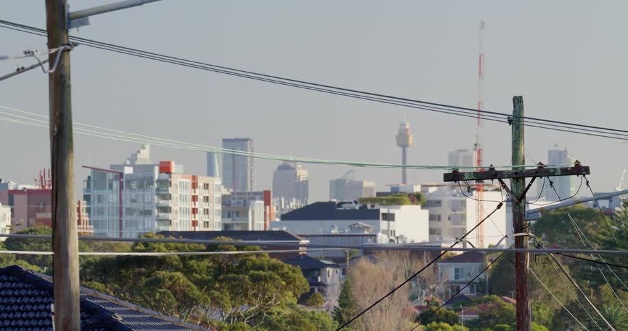 Utility poles and construction cranes around apartment buildings