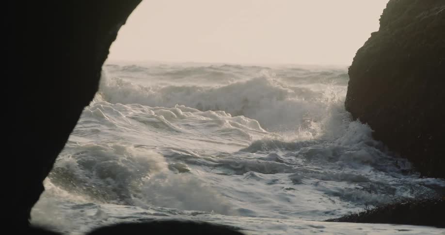 Ocean waves break against the rock on the shore