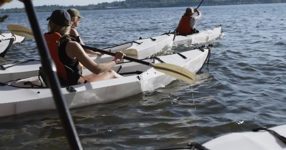 A group of people in canoes row out into a lake