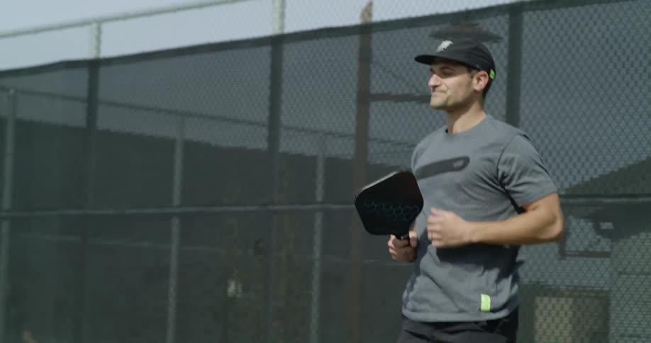 Man playing pickle ball at an outdoor court