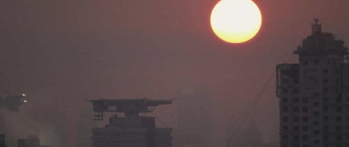 spacecrafts flying near landing pad while The sun is setting behind these buildings at dawn