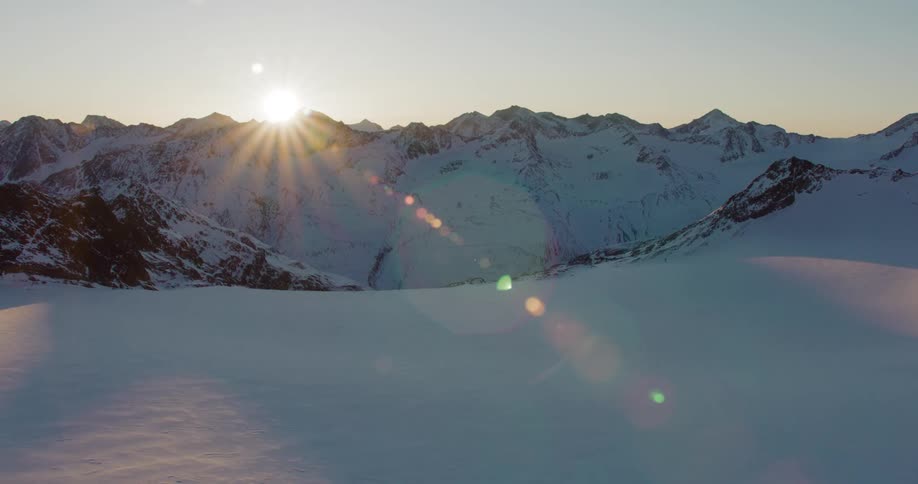 A thick layer of snow covers the ground and a rocky mountain range
