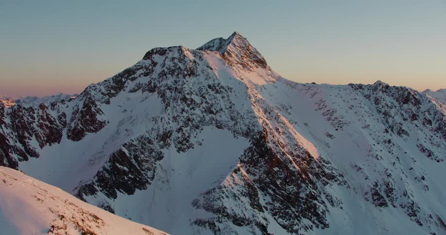Snow covered mountain peaks and ridges as the sun reflects off them