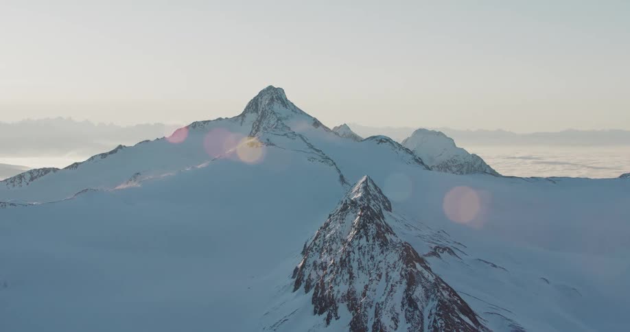 Aerial view of the snow covered slopes of a mountain peak at morning