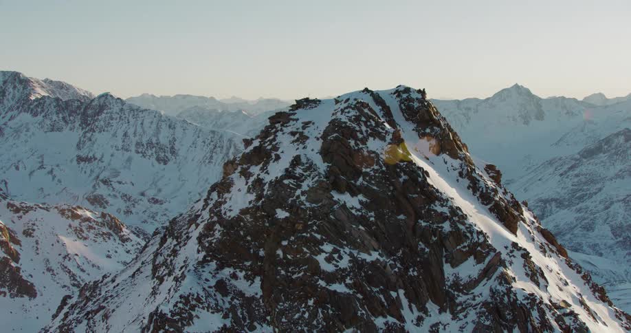 Heavy snow covers the sides and ground of a mountain range