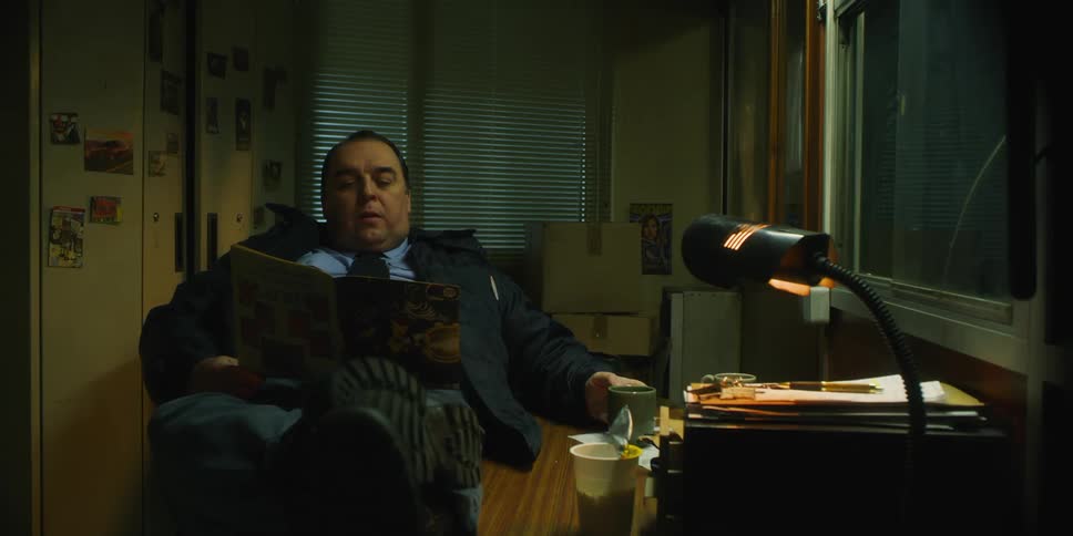 A man sits in the chair reading a magazine