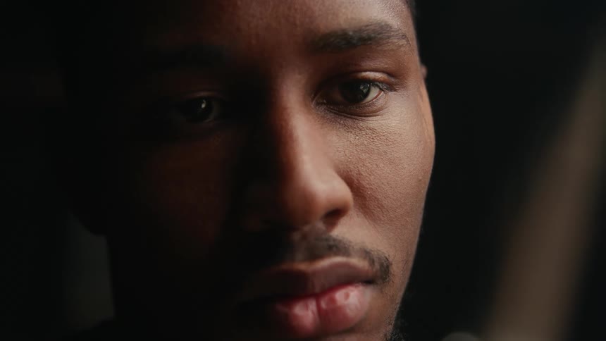 Light shines on the face of a man who appears to be in deep thought