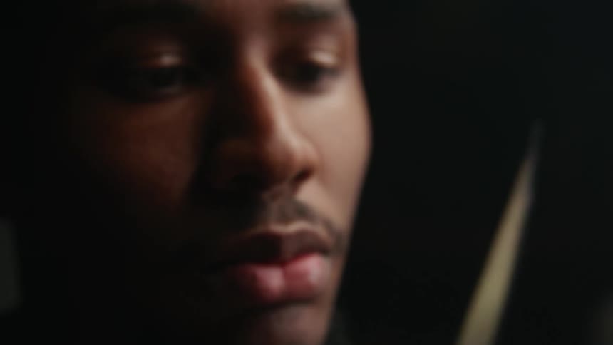An up close of a mans face looking at a knife in his hands