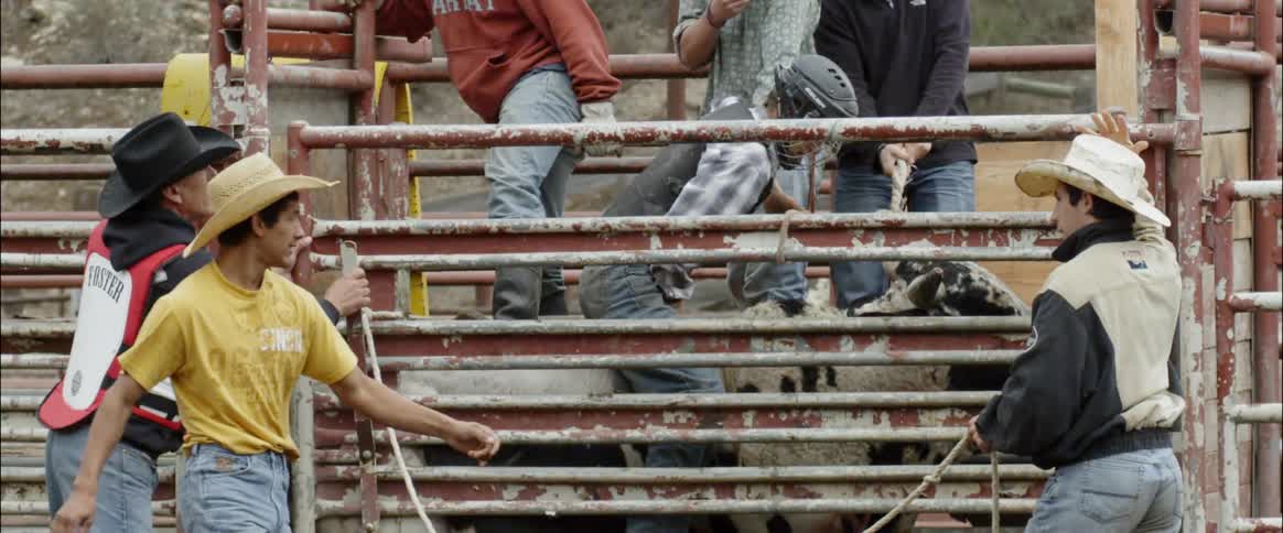 Man walks towards another man in a corral